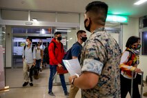 U.S. Marines Corps Lance Cpl. Jonathan Paschal, a driver within the Joint Reception Center (JRC) welcomes the new Marines to the island of Okinawa on Kadena Air Base, July 9, 2020. The JRC staff drive to Kadena Air Base to transport the Marines and greenside sailors to the barracks to execute a 14-day restriction of movement (ROM), followed by a week of welcome aboard classes to orient them to the new island. (U.S. Marine Corps photo by Lance Cpl. Karis Mattingly)