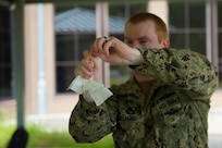 Hospital Corpsman Petty Officer 1st Class Daniel Williams, assigned to the Navy Medicine Readiness and Training Command, demonstrates how to safely put a swab in a test tube that is used to test patients for COVID-19 on July 8, 2020 at the Naval Health Clinic Charleston on Joint Base Charleston, S.C. Hospital Corpsmen from the NHCC were tasked with learning how to administer a COVID-19 swab test. The training will be used to test symptomatic patients and Sailors as well as asymptomatic Sailors to attempt to lessen the spread of the virus.