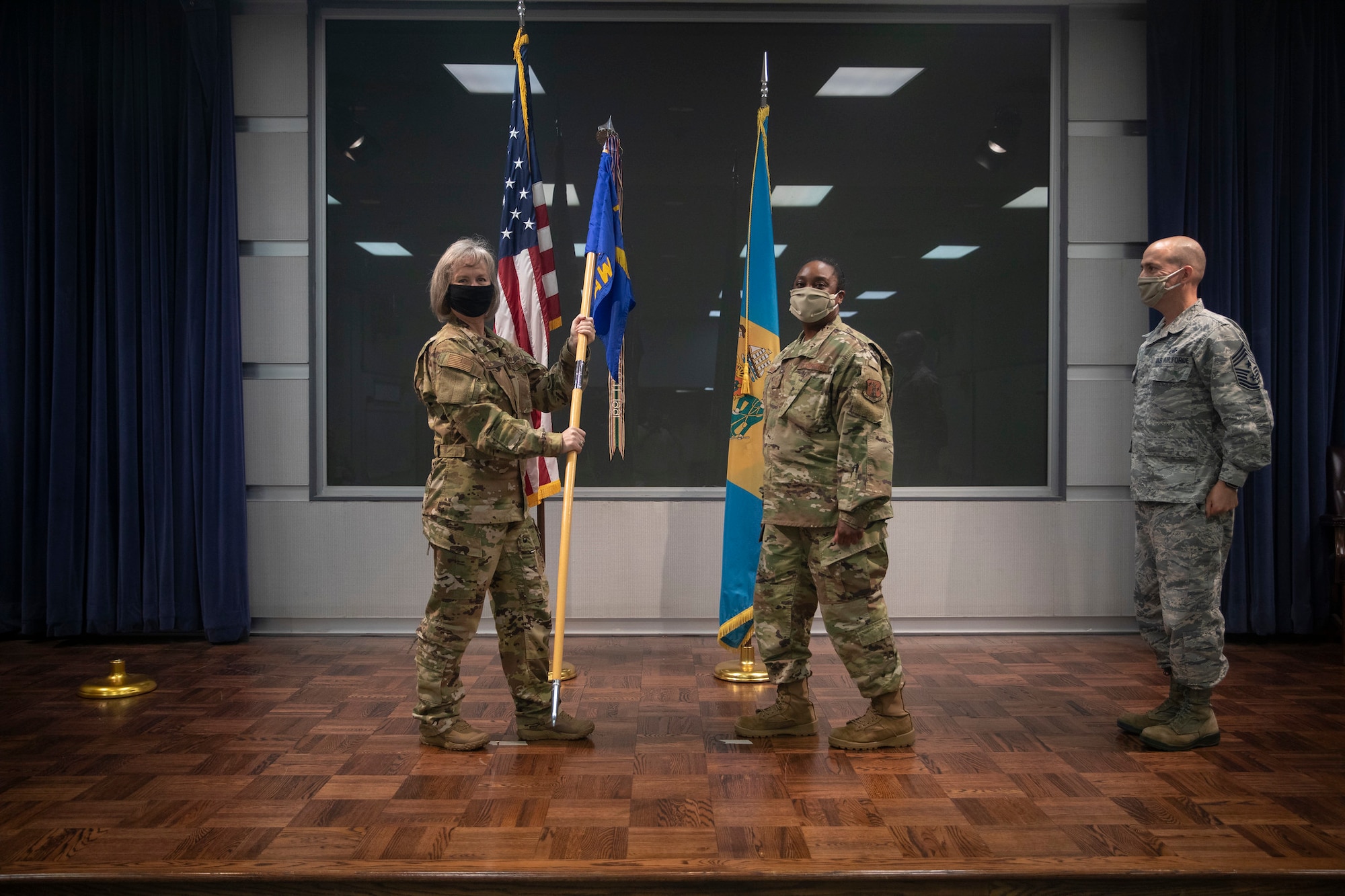 Outgoing 166th Airlift Wing Command Chief Master Sgt. William J. Horay, Jr., right, looks on as his successor, Command Chief Master Sgt. Robbin D. Moore, is introduced during their change of authority ceremony held at the New Castle ANG Base, Del. on July 12, 2020.