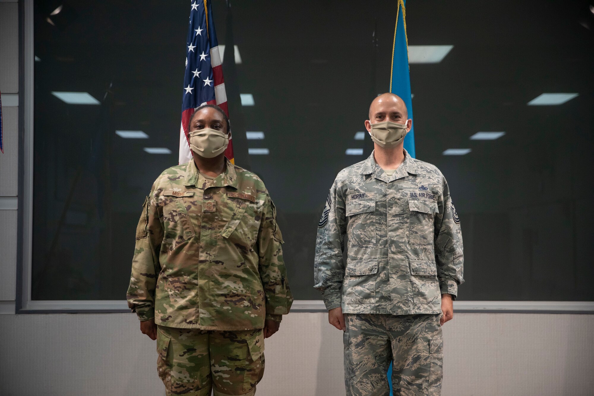 Outgoing 166th Airlift Wing Command Chief Master Sgt. William J. Horay, Jr., right, stands at attention with Command Chief Master Sgt. Robbin D. Moore during their change of authority ceremony held at the New Castle ANG Base, Del. on July 12, 2020.