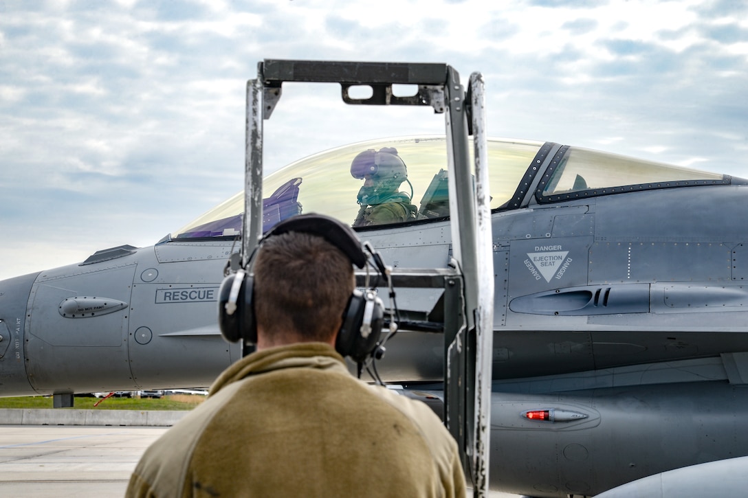 A photo of Senior Airman Colin F. Beebe preparing to install a ladder onto an F-16.