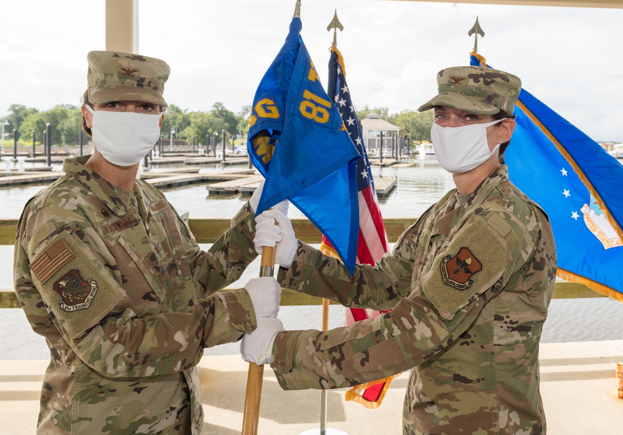 U.S. Air Force Col. Heather Blackwell, 81st Training Wing commander, takes the guidon from Col. Marcia Quigley during the 81st MSG change of command ceremony at the Marina Park at Keesler Air Force Base, Mississippi, July 16, 2020. The ceremony is a symbol of command being exchanged from one commander to the next by the handing-off of a ceremonial guidon. (U.S. Air Force Photo by Andre' Askew)