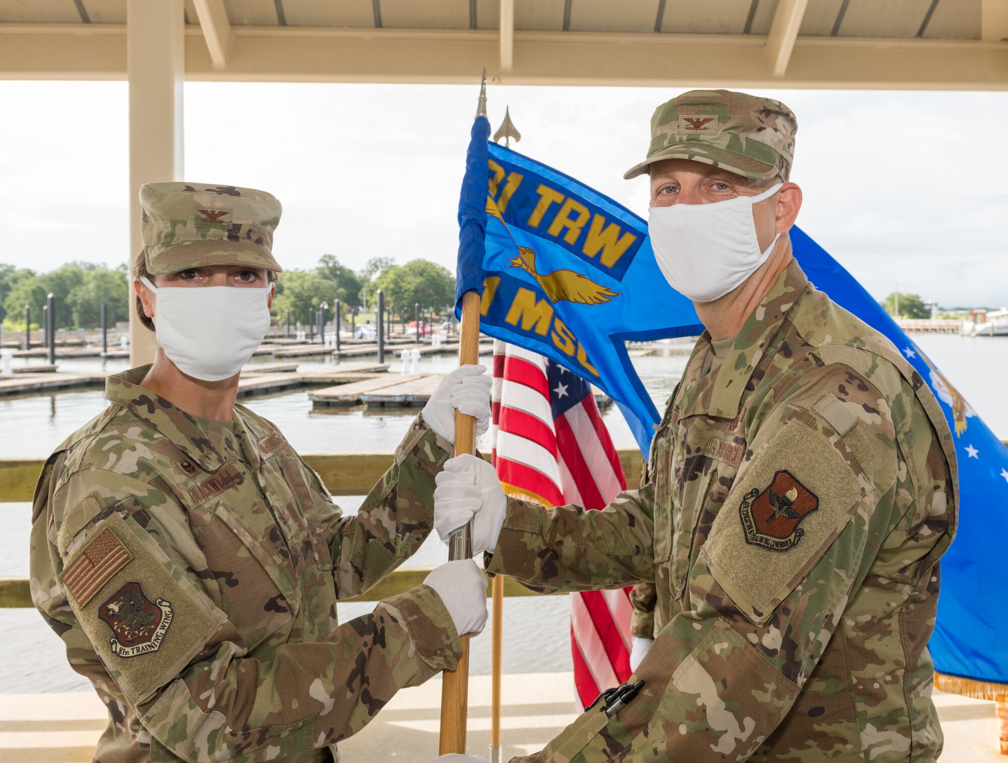 U.S. Air Force Col. Heather Blackwell, 81st Training Wing commander, passes the 81st Mission Support Group guidon to Col. Ryan Crowley, incoming 81st MSG commander, during the 81st MSG change of command ceremony at the Marina Park at Keesler Air Force Base, Mississippi, July 16, 2020. The ceremony is a symbol of command being exchanged from one commander to the next by the handing-off of a ceremonial guidon. (U.S. Air Force Photo by Andre' Askew)