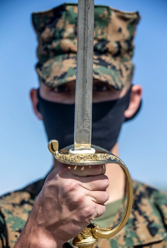 U.S. Marine Cpl. Jacob Dahl, a student with Corporals Course 3-20, hosted by Headquarters and Support Battalion, Marine Corps Base Camp Pendleton, executes present sword during sword manual practical application at the 13 Area parade deck on Camp Pendleton, California, June 12, 2020. The Marine noncommissioned officer’s sword is authorized for use by all enlisted Marines in the grade of corporal through sergeant major for parades, reviews and other ceremonies. Dahl is a native of San Clemente, California. (U.S. Marine Corps photo by Lance Cpl. Alison Dostie)