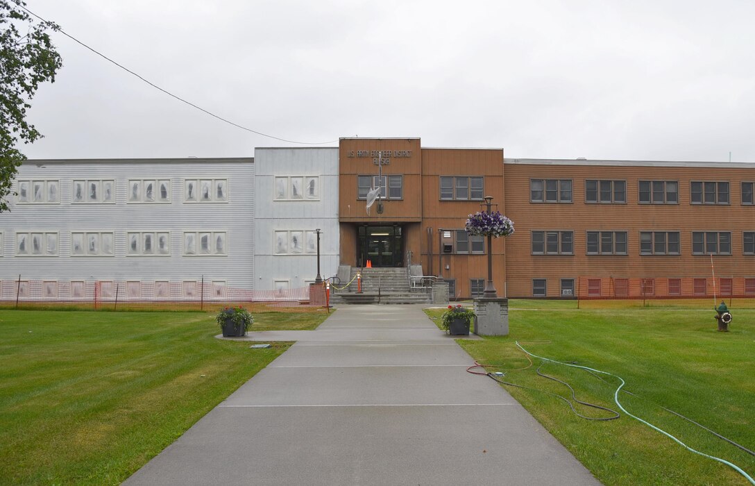 Midway through work on the exterior of the headquarters building, painters applied primer to the left side.