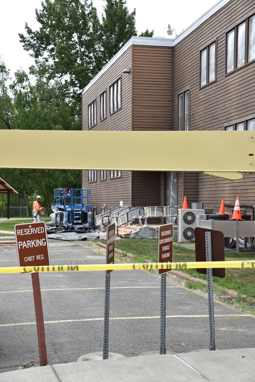 Equipment sits near the building as workers prepare the northeast side for primer and paint.