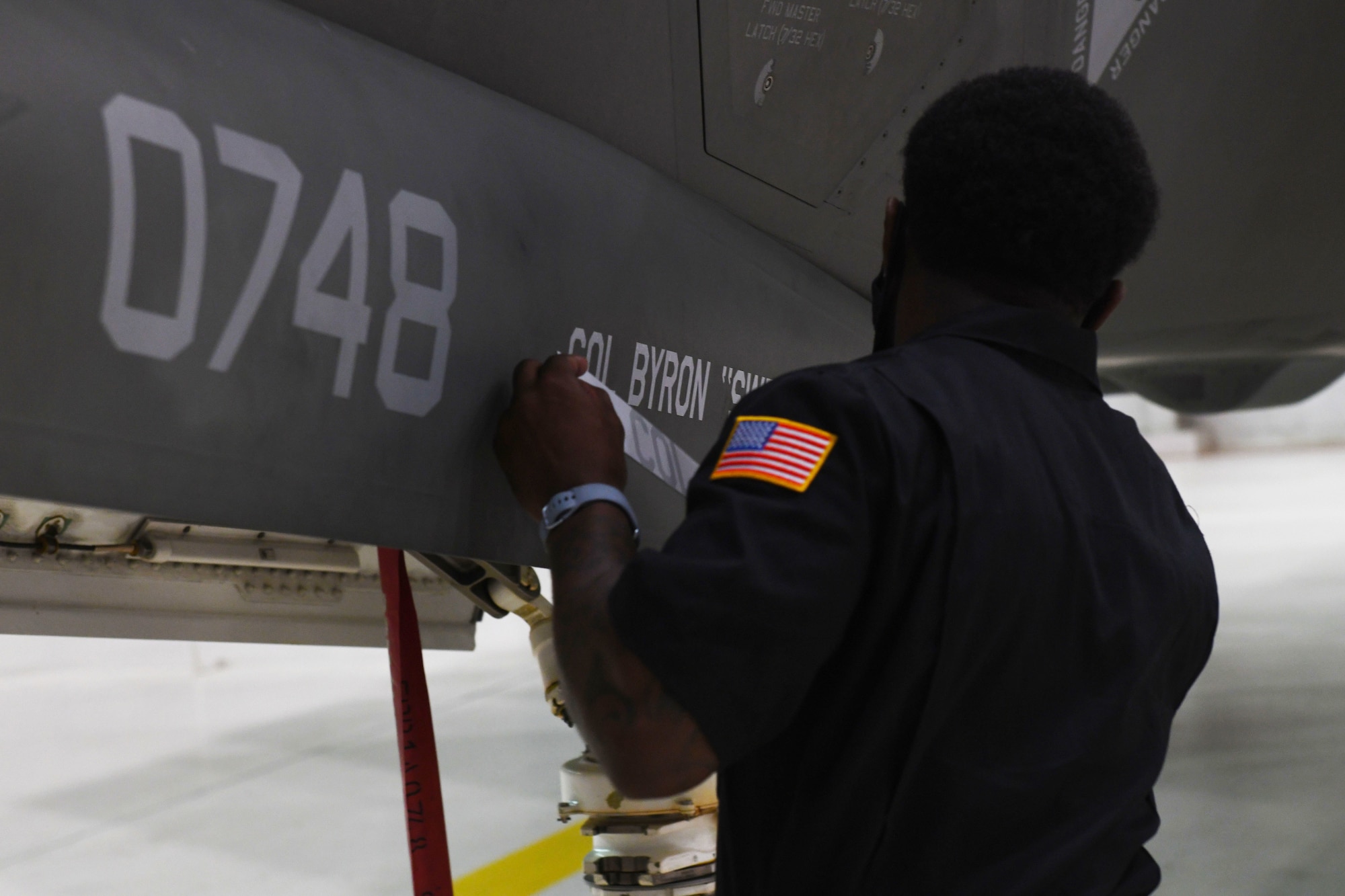 A 33rd OG crew chief reveals Col. Byron Popma’s name alongside the group’s flagship, during the 33rd OG change of command at Eglin Air Force Base, Florida, July 17, 2020. Pompa was previously the U.S. Air Forces Central Command Director of Operations, Southwest Asia. (U.S. Air Force photo by Airman 1st Class Heather Leveille)