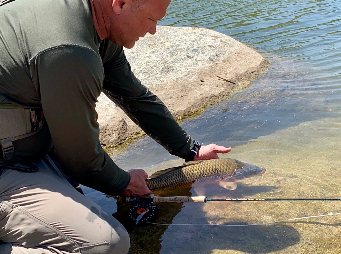 U.S. Marine Col. Christeon Griffin, commanding officer of Headquarters Battalion, 1st Marine Division, releases a carp back into the water at Case Springs Camp Pendleton Ca. Col. Griffin is one of the installations many avid fishermen and enjoys the on-base fishing opportunities.
