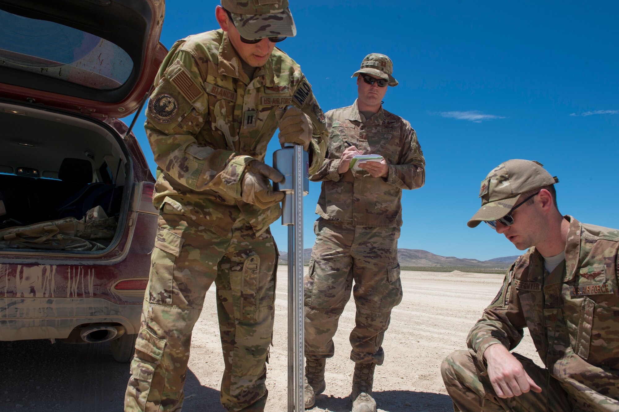 Three 621st Mobility Support Operations Squadron air mobility liaison officers use a dynamic cone penetrometer to measure the hardness of the runway after two  C-17 Globemaster IIIsused the location to land and takeoff July14, 2020 at Fort Irwin, Calif. AMLOs regularly work and deploy with Army and Marine Corps units. (U.S. Air Force photo by Staff Sgt. Sarah Brice)