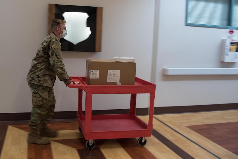Airman 1st Class Bailey Pitcher, 22nd Medical Support Squadron acquisitions technician, delivers packages to different clinics throughout the 22nd Medical Group July 15, 2020, at McConnell Air Force Base, Kansas. Medical material deliver medication, supplies and equipment they need throughout the 22nd Medical Group in support of their mission to keep Team McConnell healthy. (U.S. Air Force photo by Senior Airman Alexi Bosarge)