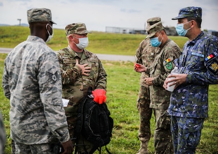 Tech Sergeant Matthew Stambaugh explains a training aide to several Romanian service members at the Alabama Air National Guard 117th Air Refueling Wing in Birmingham, Ala., June 3, 2020.