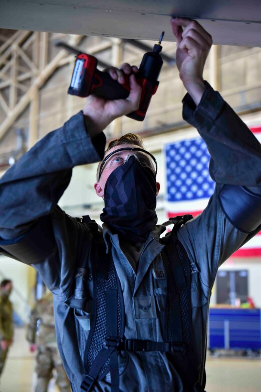 Airman 1st Class Avery Justice, 92nd Maintenance Squadron crew chief, removes screws from the bottom of a KC-135 Stratotanker wing while wearing an exoskeleton apparatus at Fairchild Air Force Base, Washington, July 16, 2020. The exoskeleton apparatus is used to relieve pressure off of the shoulders and back of Airmen. (U.S. Air Force photo by Airman 1st Class Kiaundra Miller)