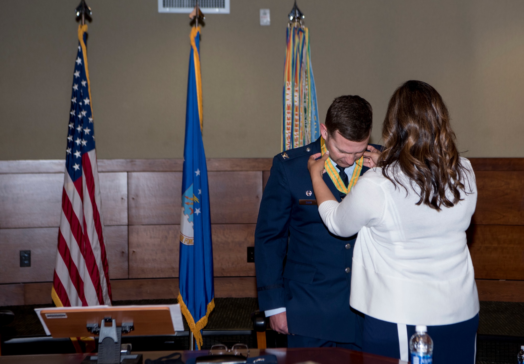 Kathy Davis, spouse of outgoing 3rd Wing commander, U.S. Air Force Col. Robert Davis, gives the Alaska Legion of Merit medal to her husband as he relinquishes command of the wing to U.S. Air Force Col. Travolis Simmons during the 3rd WG change of command ceremony at Joint Base Elmendorf-Richardson, Alaska, July 17, 2020. The 3rd WG provides trained and equipped tactical air dominance forces, command and control platforms, and strategic and tactical airlift resources for contingency operations and also provides immediate early airborne detection, warning, surveillance and interception of hostile forces within the Alaskan North American Aerospace Defense Command Region. The ceremony was adapted to comply with COVID-19 health and safety measures.
