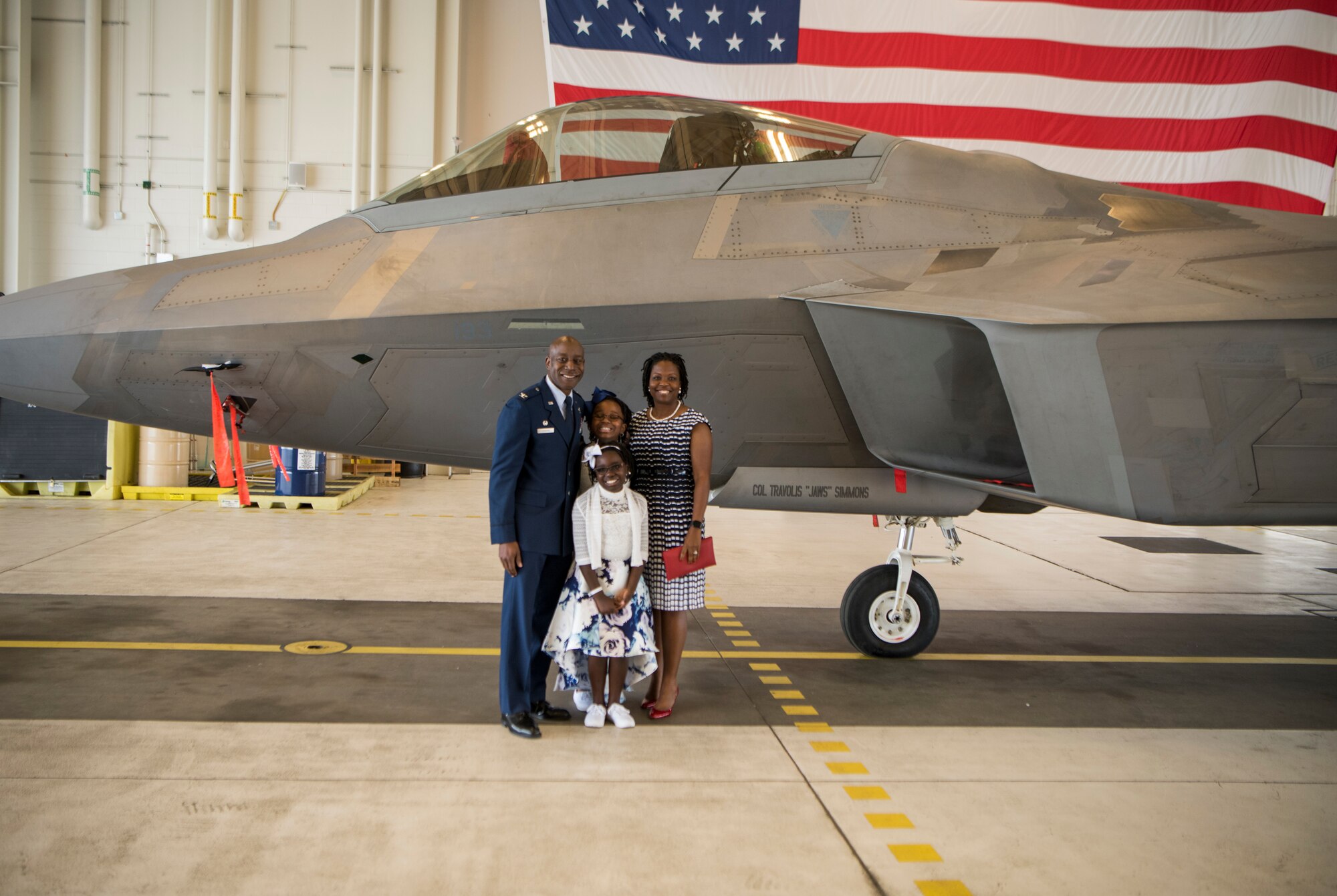 U.S. Air Force Col. Travolis Simmons, his wife Jamese, and daughters Victoria and Elizabeth, pose for a photo in front of a U.S. Air Force F-22 Raptor that was unveiled with his name as he assumed command of the 3rd Wing at Joint Base Elmendorf-Richardson, Alaska, July 17, 2020. The 3rd WG provides trained and equipped tactical air dominance forces, command and control platforms, and strategic and tactical airlift resources for contingency operations and also provides immediate early airborne detection, warning, surveillance and interception of hostile forces within the Alaskan North American Aerospace Defense Command Region. The ceremony was adapted to comply with COVID-19 health and safety measures.