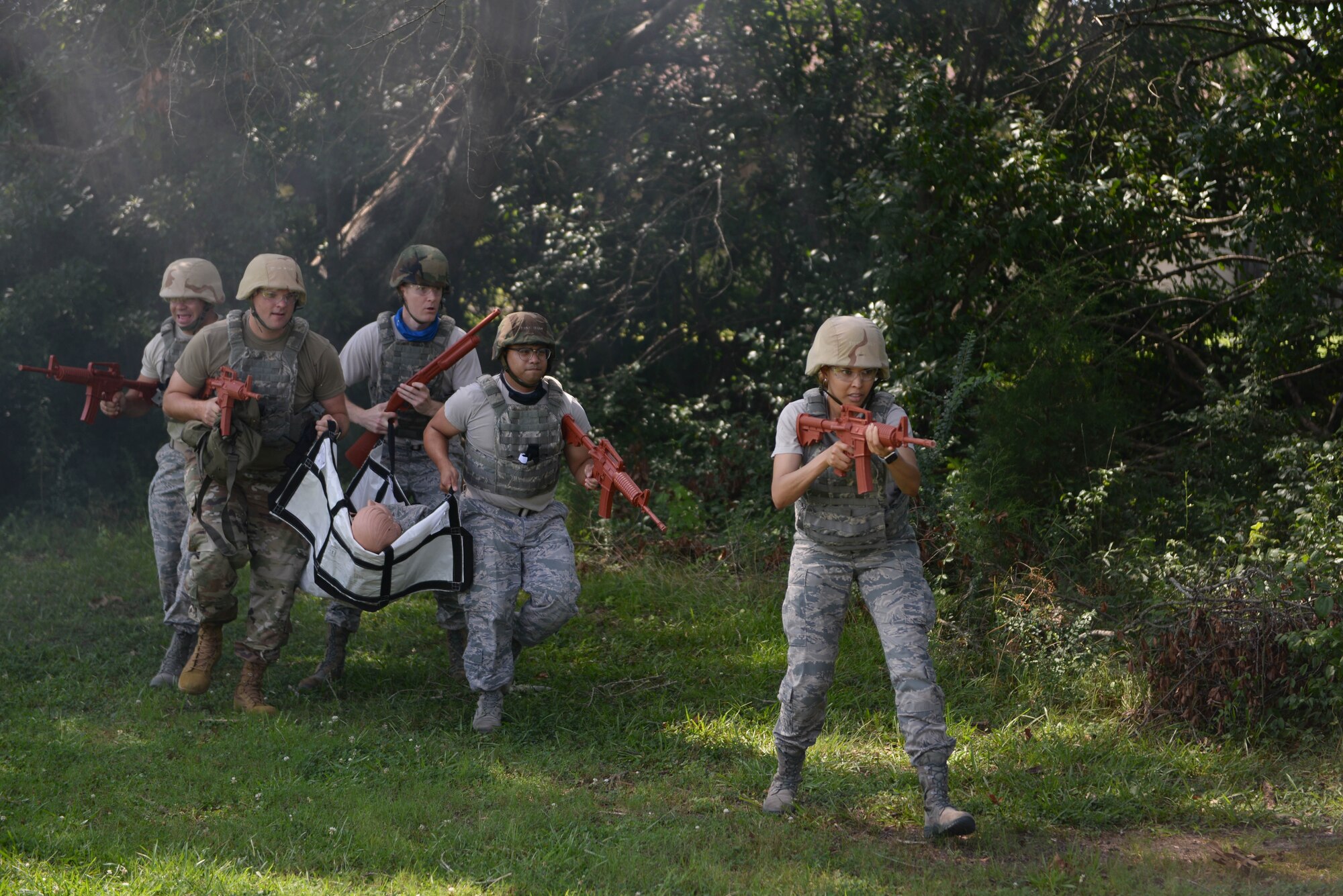 14th Medical Group Airmen carry an augmented mannequin in a simulated battlefield during the Tactical Combat Casualty Care All Combatants course July 16, 2020, at the Kortiz Clinic on Columbus Air Force base, Miss. During the exercise, medics practiced treatment on augmented mannequins as well as volunteers with replicated battle wounds in order to simulate the look, feel and smell of severe traumatic injuries on a live human. (U.S. Air Force photo by Airman 1st Class Davis Donaldson)