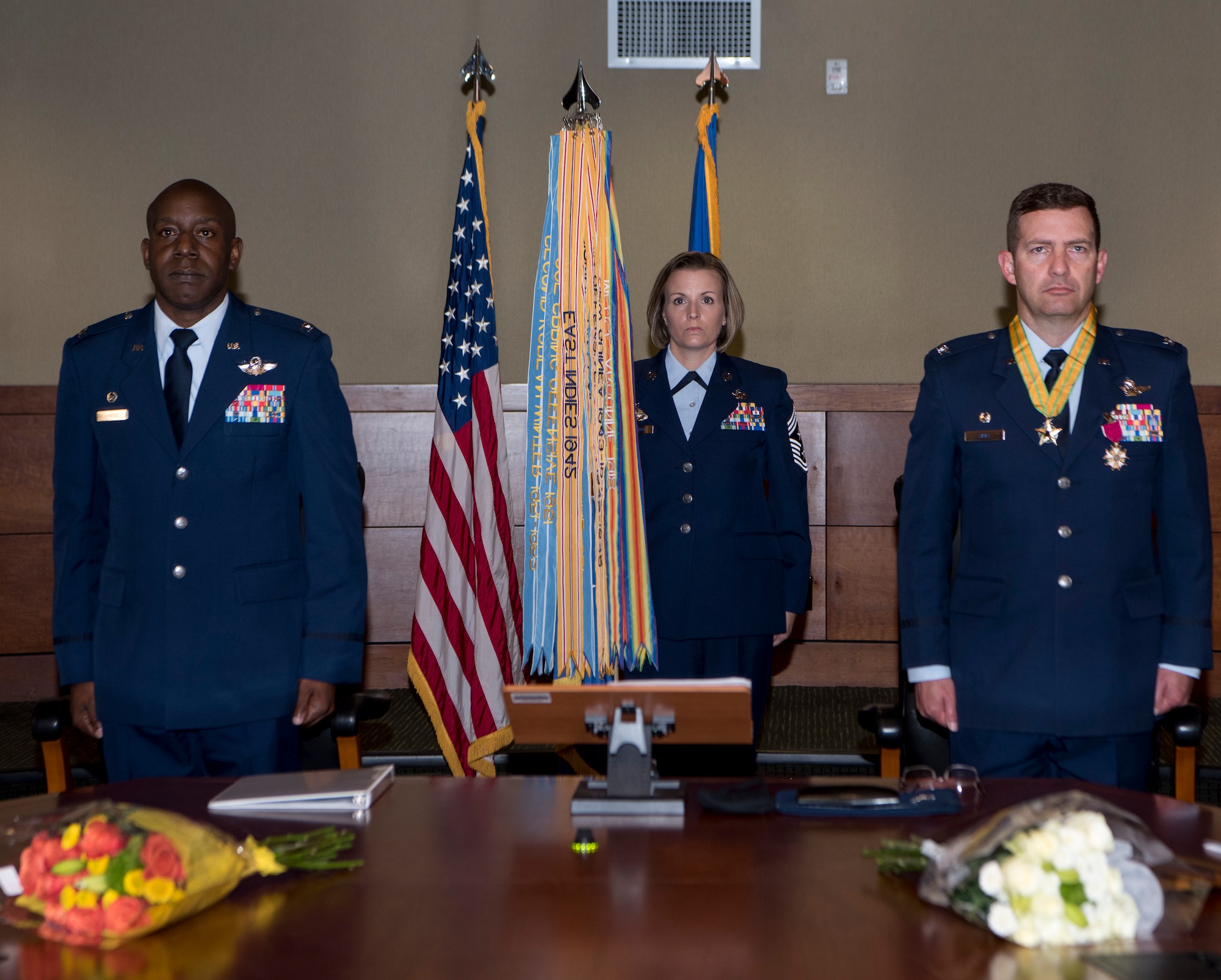 U.S. Air Force Command Chief Master Sgt. Rebecca Bateman center, holds the 3rd Wing flag as she assumes her role as the new command chief for the 3rd WG during a change of command ceremony, as U.S. Air Force Col. Robert Davis right relinquishes command of the wing to U.S. Air Force Col. Travolis Simmons at Joint Base Elmendorf-Richardson, Alaska, July 17, 2020. The 3rd WG provides trained and equipped tactical air dominance forces, command and control platforms, and strategic and tactical airlift resources for contingency operations and also provides immediate early airborne detection, warning, surveillance and interception of hostile forces within the Alaskan North American Aerospace Defense Command Region. The ceremony was adapted to comply with COVID-19 health and safety measures.