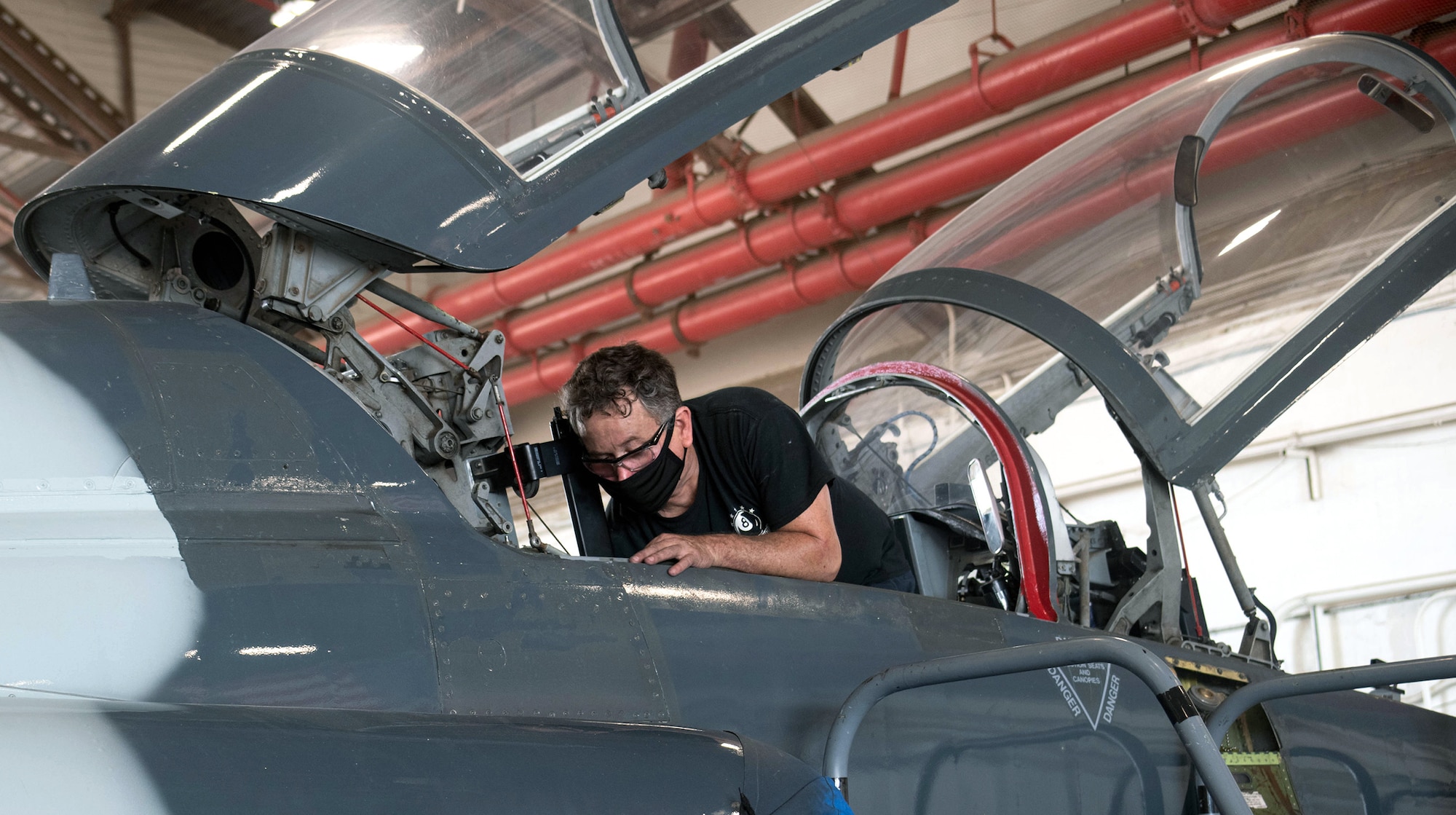 Tom Brewer, 12th Maintenance Squadron maintainer, wears a face mask as he repairs a T-38C seat hinge at Joint Base San Antonio-Randolph July 14.