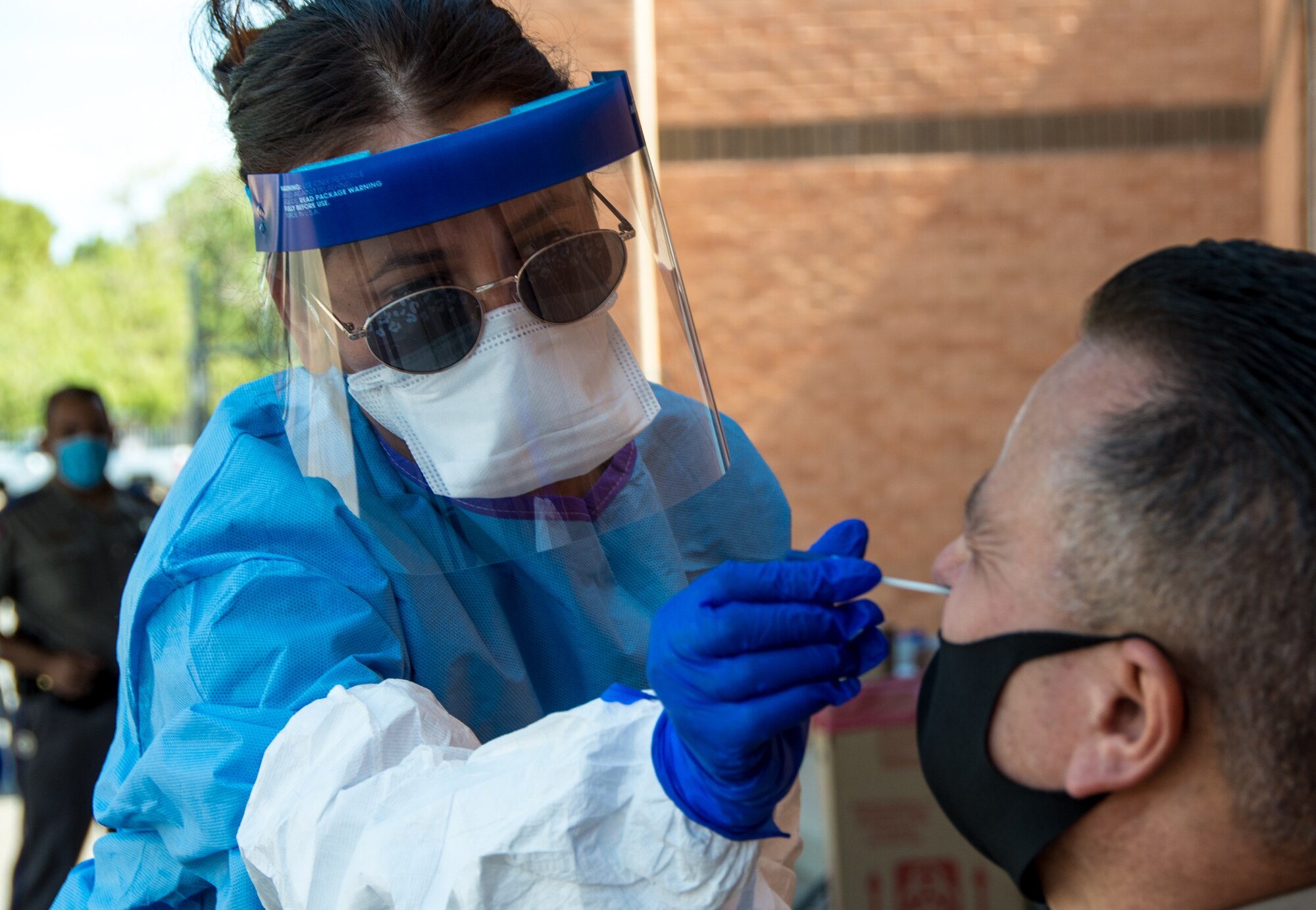 Airman administers a COVID-19 test.