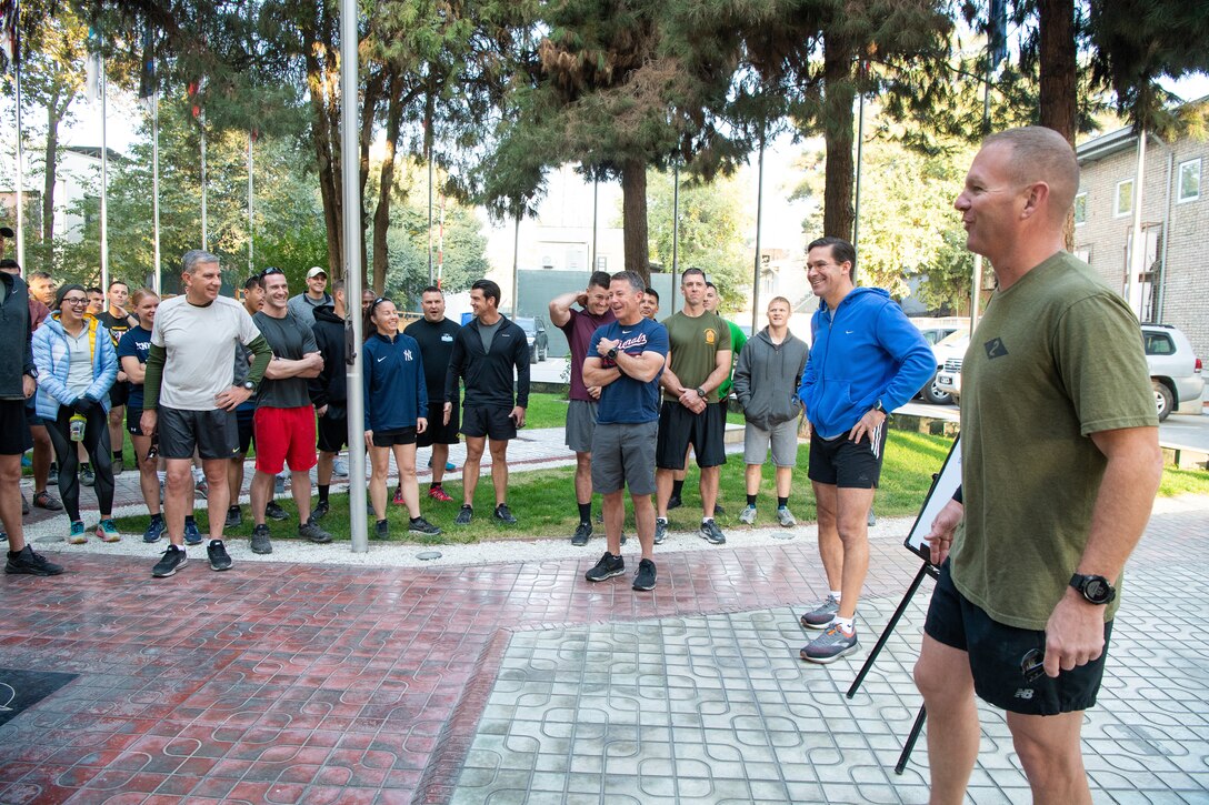 Men and women in PT outfits ready for training.