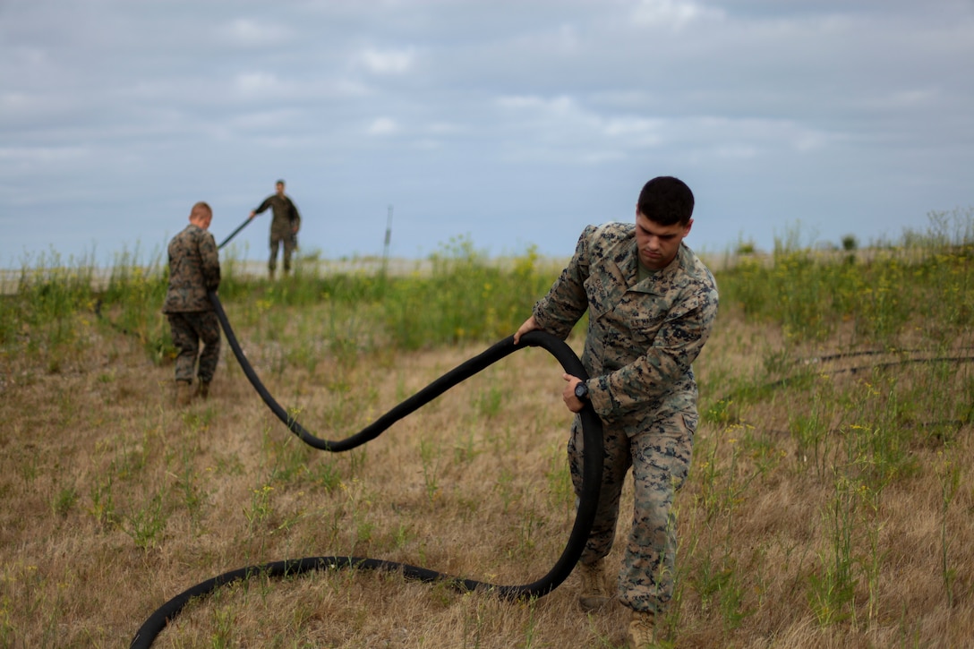 U.S. Marines with Marine Medium Tiltrotor Squadron 164 (Reinforced), 15th Marine Expeditionary Unit, pull a fuel hose during a forward arming and refueling point exercise at Marine Corps Base Camp Pendleton, California, July 15, 2020. The FARP mission allows military aircraft to refuel and re-arm at a forward located position, allowing them to get back into the fight in less time than returning to the air station they originated from. (U.S. Marine Corps photo by Cpl. Patrick Crosley)