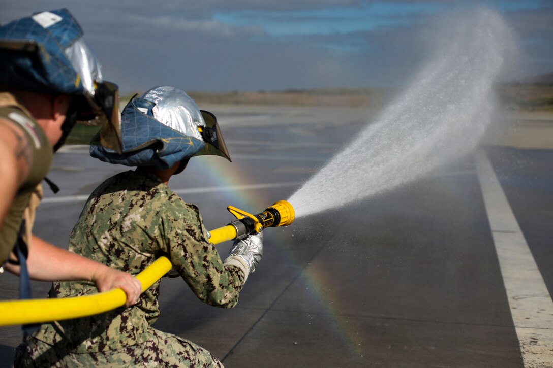 U.S. Marines and Sailors with 15th Marine Expeditionary Unit learn how to operate a firehose during a forward arming and refueling point exercise at Marine Corps Base Camp Pendleton, California, July 15, 2020. The FARP mission allows military aircraft to refuel and re-arm at a forward located position, allowing them to get back into the fight in less time than returning to the air station they originated from. (U.S. Marine Corps photo by Cpl. Patrick Crosley)