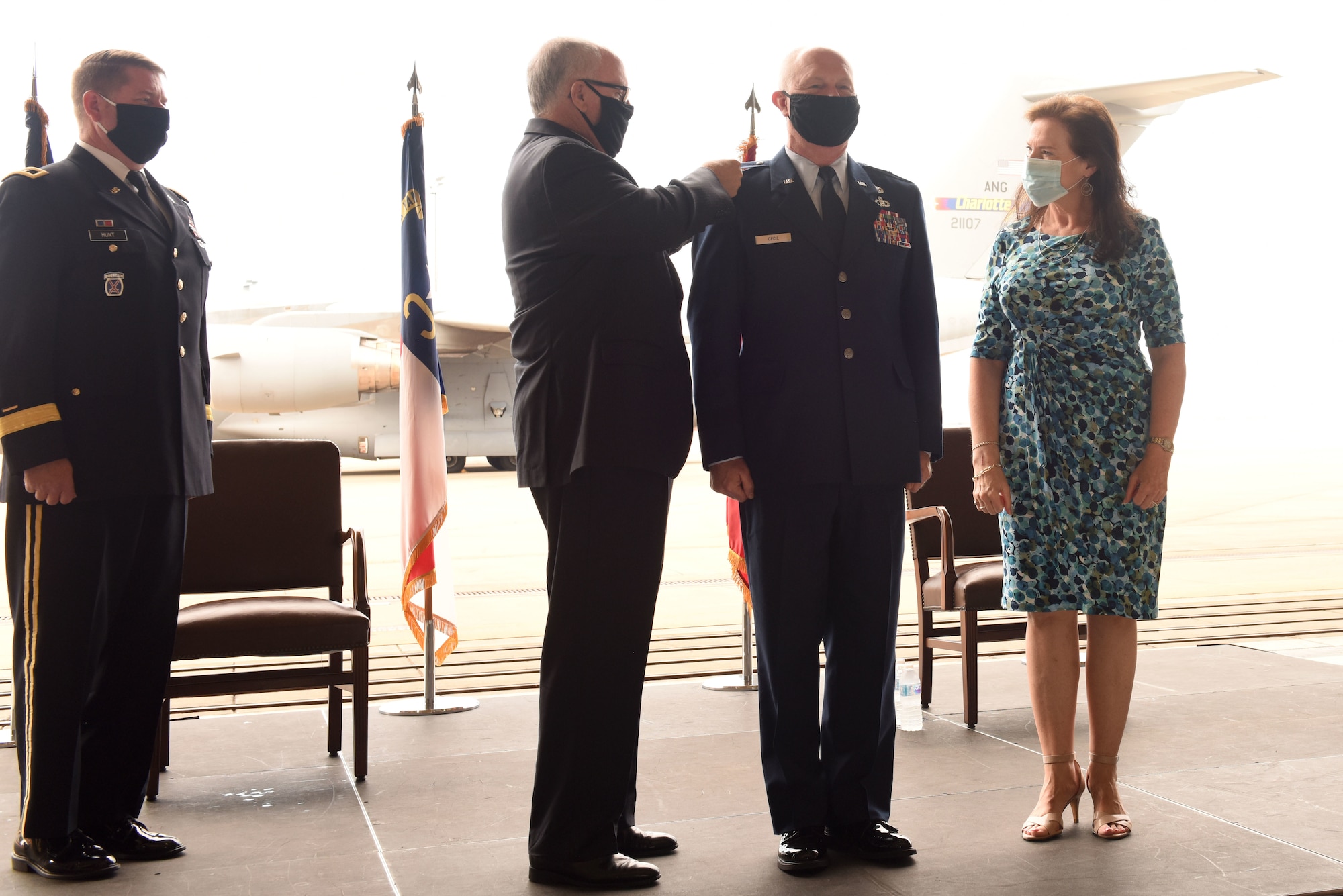 U.S. Air Force Brig. Gen. Allan R. Cecil (center-right), North Carolina National Guard Chief of Staff, is assisted with putting on new rank by his wife Jane (right), and Brig. Gen. (Retired) Iwan Clontz (center-left), during Brig. Gen. Cecil’s promotion ceremony at the North Carolina Air National Guard Base, Charlotte Douglas International Airport, July 18, 2020. Family, friends, and guard members gather to watch Col. Cecil pin on the rank of Brigadier General.