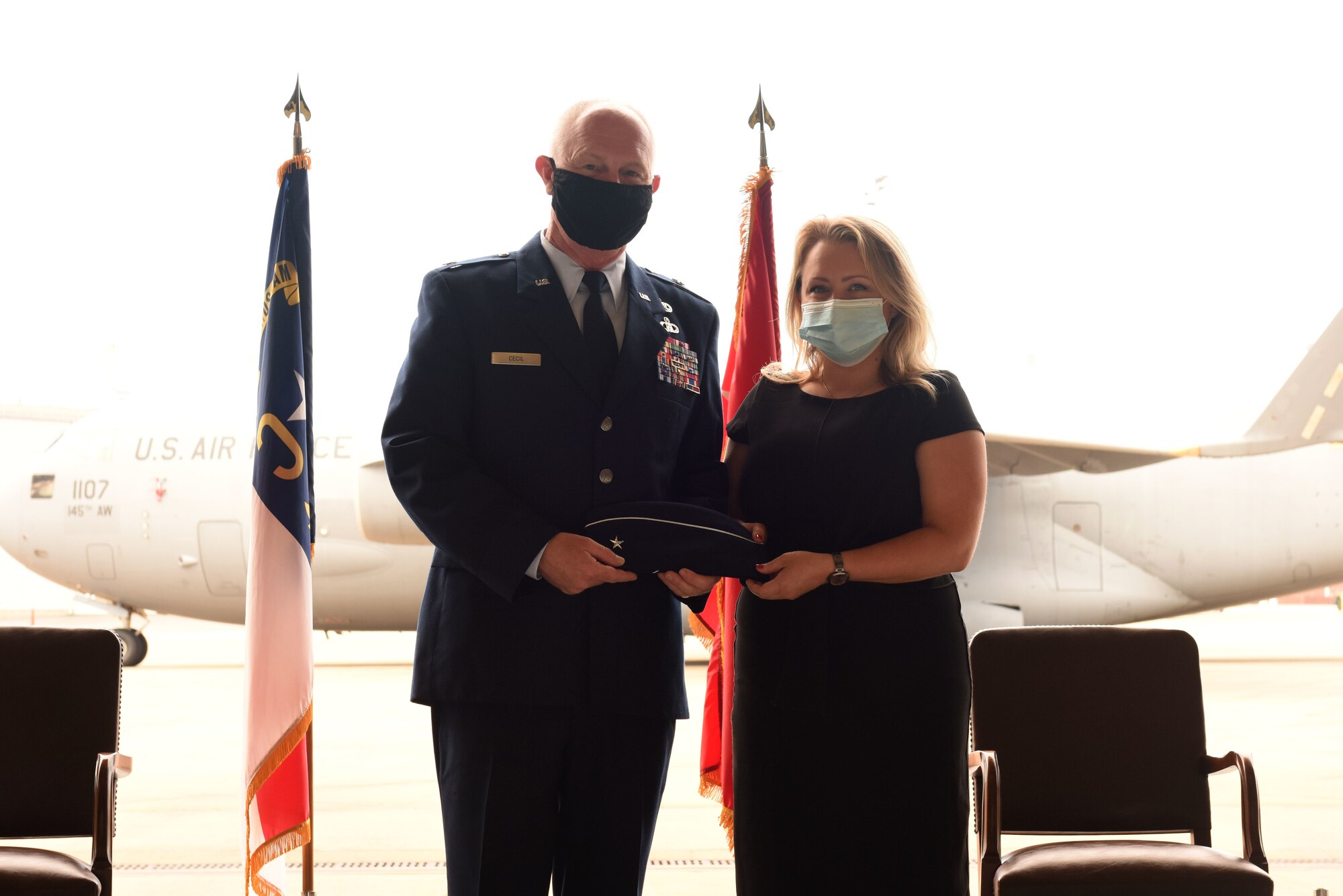 U.S. Air Force Brig. Gen. Allan R. Cecil (left), North Carolina National Guard (NCNG) Chief of Staff, is presented his new cover with rank emblem by Amanda Fox during Brig. Gen. Cecil’s promotion ceremony at the North Carolina Air National Guard Base, Charlotte Douglas International Airport, July 18, 2020. Family, friends, and guard members gather to watch Col. Cecil pin on the rank of Brigadier General.