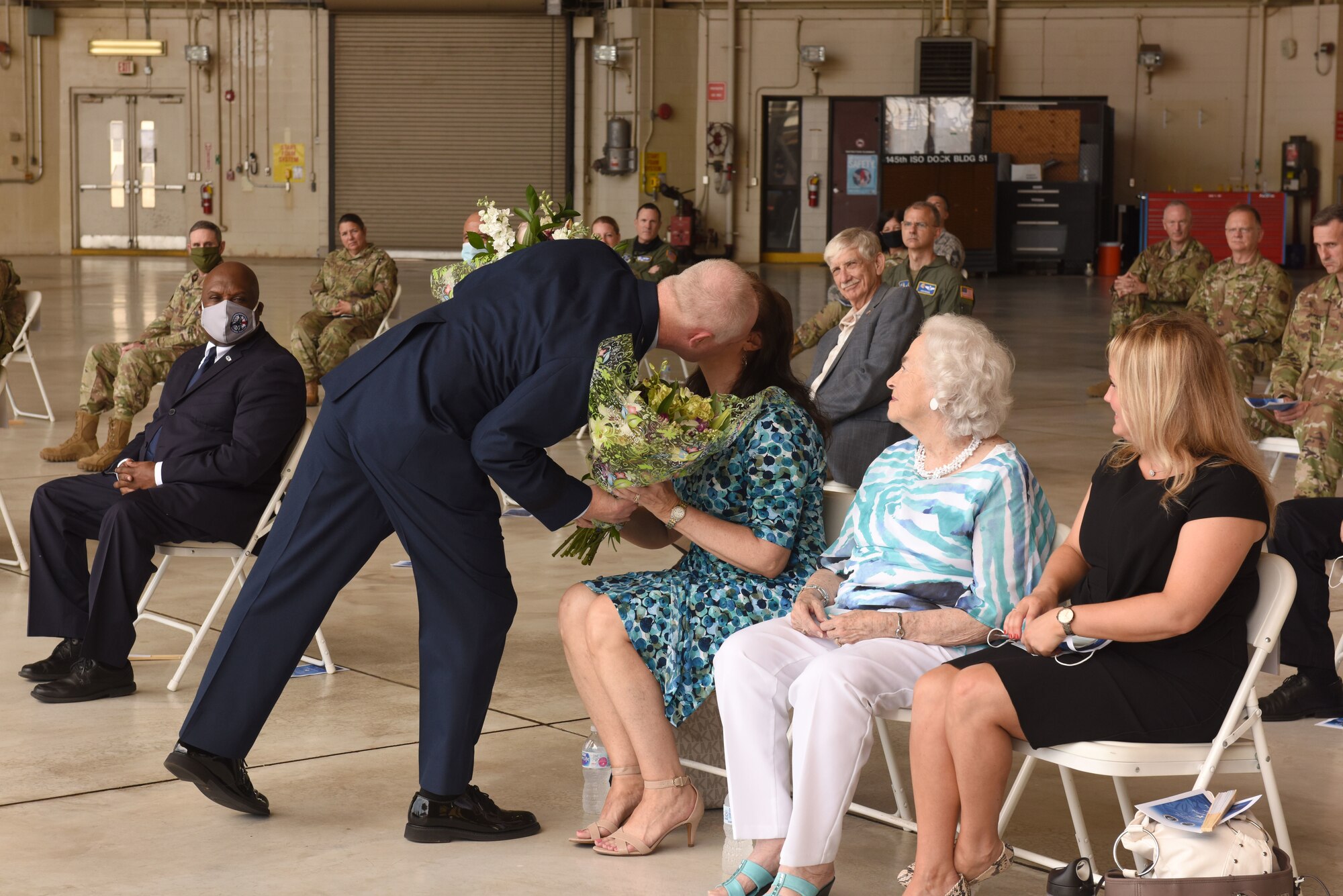 U.S. Air Force Brig. Gen. Allan R. Cecil, North Carolina National Guard (NCNG) Chief of Staff, gifts his wife, Jane, a bouquet of flowers as a token of his appreciation for her love and support over the years during his promotion ceremony at the North Carolina Air National Guard Base, Charlotte Douglas International Airport, July 18, 2020. Family, friends, and guard members gather to watch Col. Cecil pin on the rank of Brigadier General.