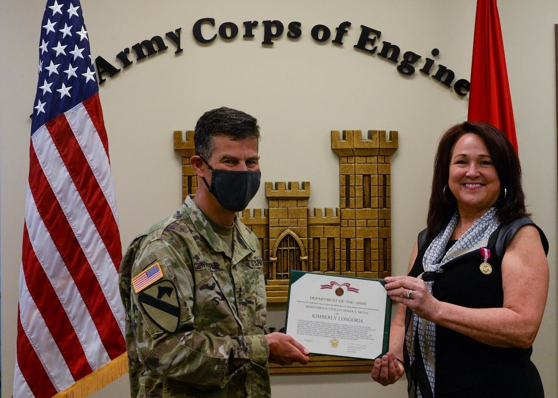 Great Lakes and Ohio River Division Commander Maj. Gen. Robert F. Whittle Jr., presents Kim Longoria executive officer a Meritorious Civilian Service Medal from for her leadership and contribution toward the division's success during the COVID-19 response mission.