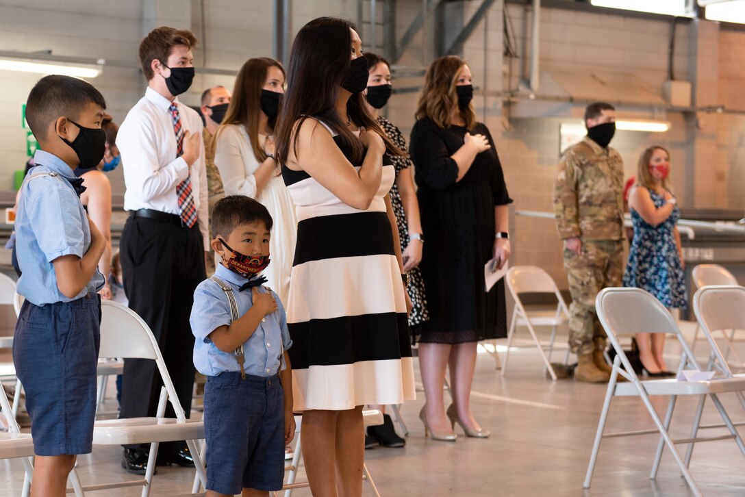 U.S. Air Force Maj. Chin T. Hsu’s family stand for the playing of the national anthem during the 423rd Civil Engineer Squadron Change of Command ceremony at RAF Alconbury, England, July 17, 2020. The change of command ceremony is rooted in military history dating back to the 18th century representing the relinquishing of power from one officer to another. (U.S. Air Force photo by Airman 1st Class Jennifer Zima)