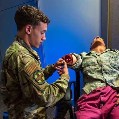 A man works on a mannequin.