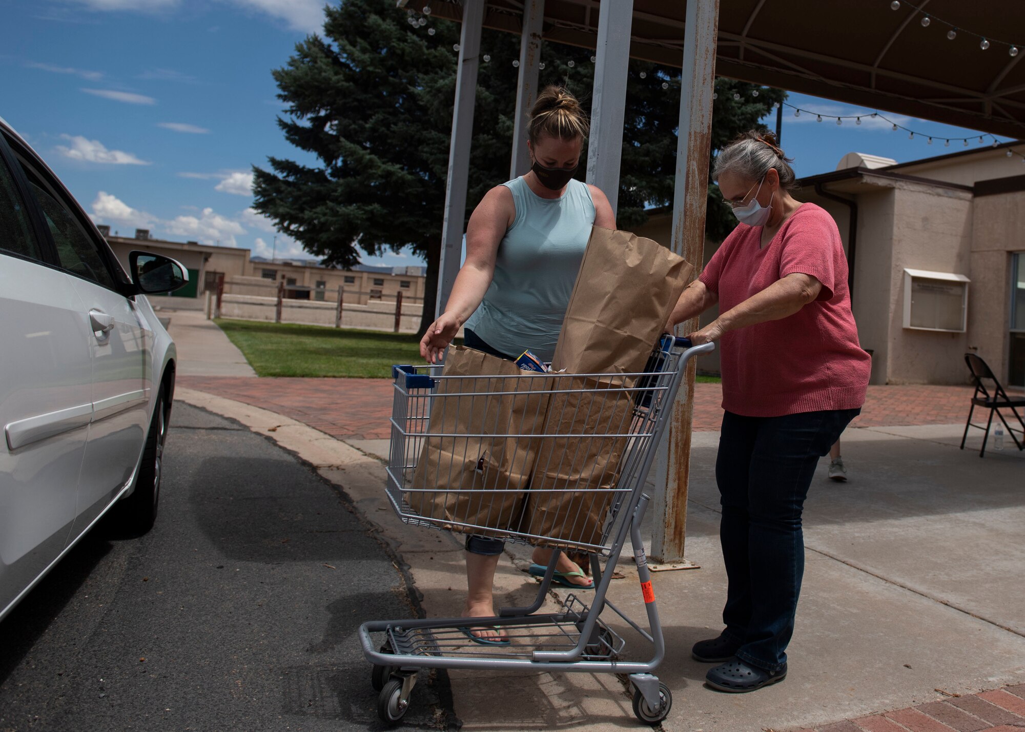 Members of the Kirtland Spouses Club receive donation items.