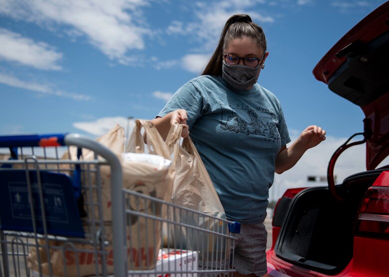 Members of the Kirtland Spouses Club receive donation items.