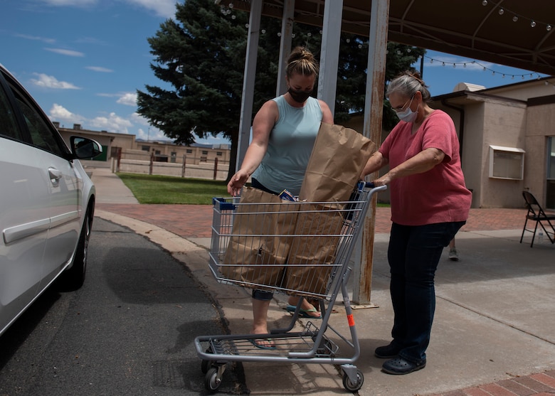Members of the Kirtland Spouses Club receive donation items.