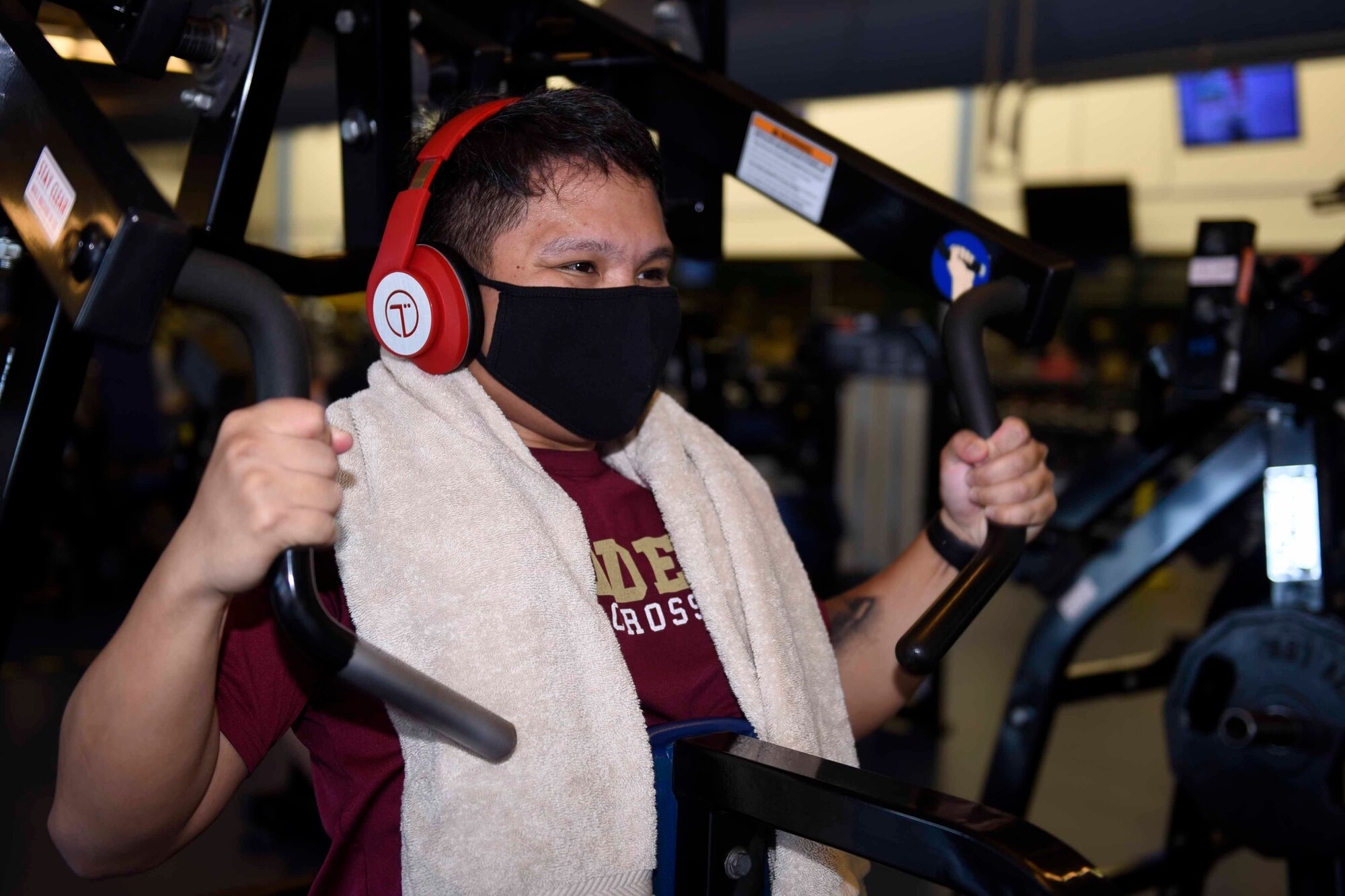 U.S. Air Force Airman 1st Class Arron Bautista, 60th Inpatient Squadron critical care technician, performs chest presses June 24, 2020, at Travis Air Force Base, California. Fitness center patrons are required to wear masks and bring a towel to prevent the spread of COVID-19 while exercising in the facility. (U.S. Air Force photo by Airman 1st Class Cameron Otte)