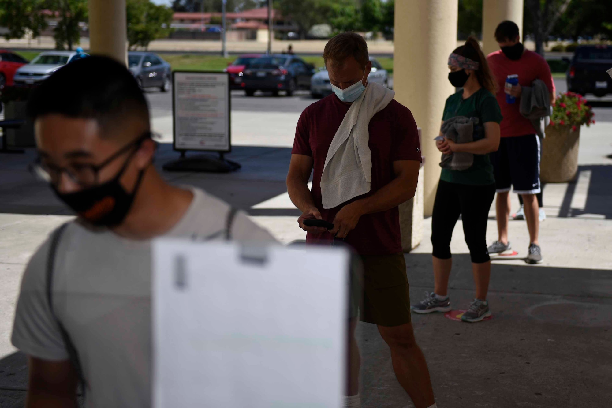 Active-duty U.S. service members wait to enter the fitness center June 24, 2020, at Travis Air Force Base, California. To prevent the spread of COVID-19, fitness center patrons must practice physical distancing at all times. (U.S. Air Force photo by Airman 1st Class Cameron Otte)