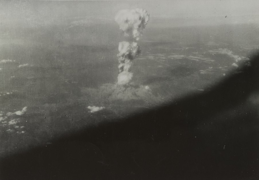 A mushroom cloud can be seen over land.