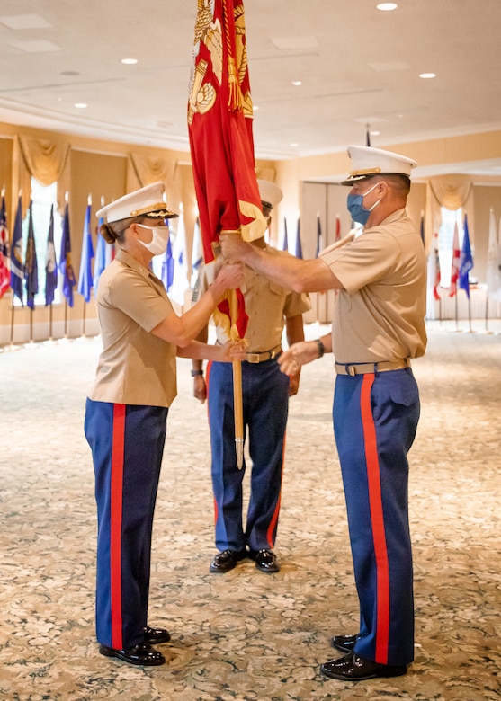 U.S. Marine Corps Col. Robert M. Clark, right, passes the unit's colors to Col. Heather J. Cotoia during the 4th Marine Corps District change of command ceremony at the West Shore Country Club, Camp Hill, Pennsylvania, July 16, 2020. The passing of the unit colors symbolizes the official transfer of authority between the two officers.  (U.S. Marine Corps Photo by Cpl. Cody J. Ohira)