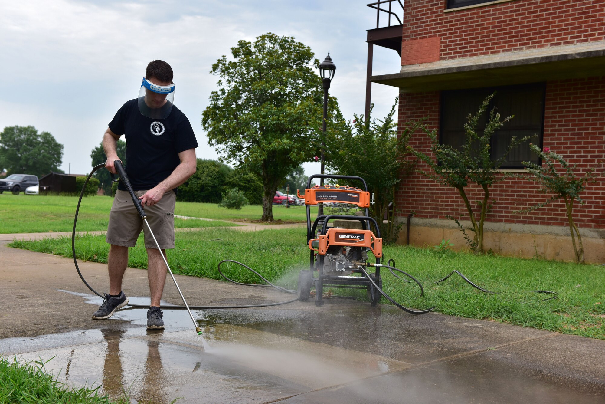Airman using powerwasher cleaning off sidewalk