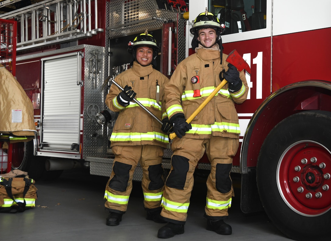 Airman 1st Class Josiah Jordan and Airman 1st Class Colton Clifton, firefighters from the 316th Civil Engineer Squadron, pose for a photo in their personal protective equipment at Fire Station One on Joint Base Andrews, Md., July 17, 2020.