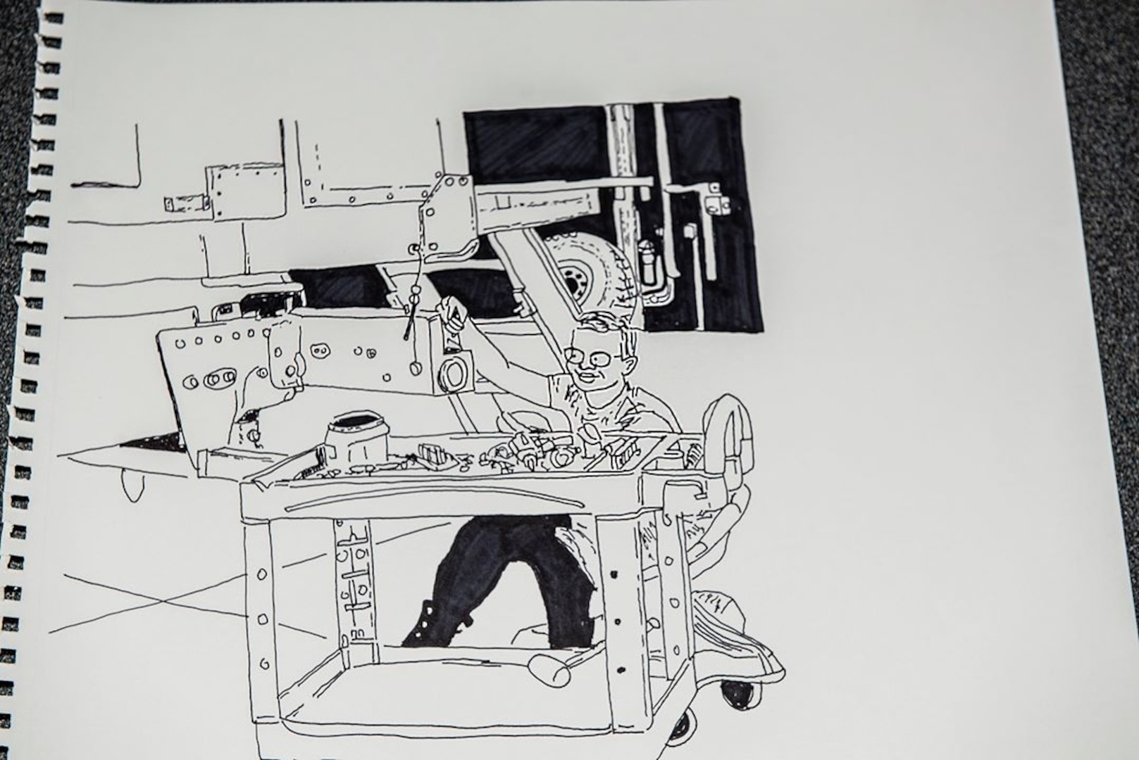 A NHARNG mechanic at work at a field maintenance shop is depicted here in one of Pfc. Kevin Blackstone's many drawings.