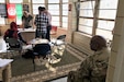 A group of people stand around a table.