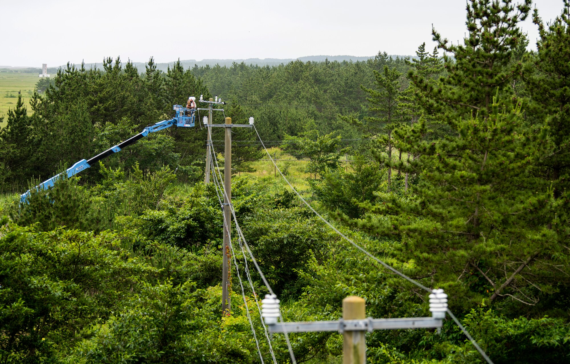 The 35th Civil Engineer Squadron and Japan Air Self-Defense Force Airmen equivalent, work together to replace deteriorating high voltage overhead lines at Draughon Range in Misawa, Japan, July 15.