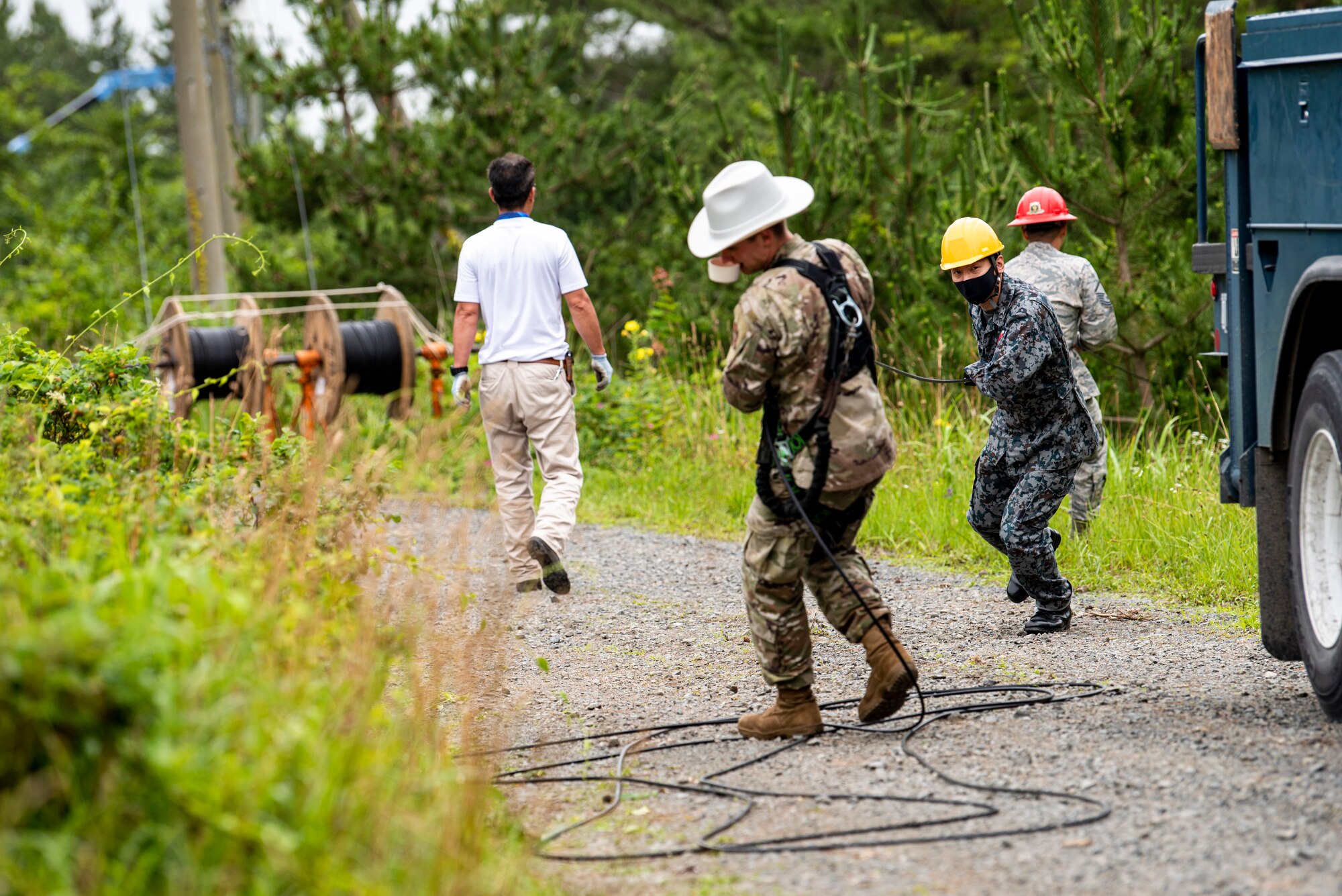 The 35th Civil Engineer Squadron and Japan Air Self-Defense Force Airmen equivalent, work together to replace deteriorating high voltage overhead lines at Draughon Range in Misawa, Japan, July 15.