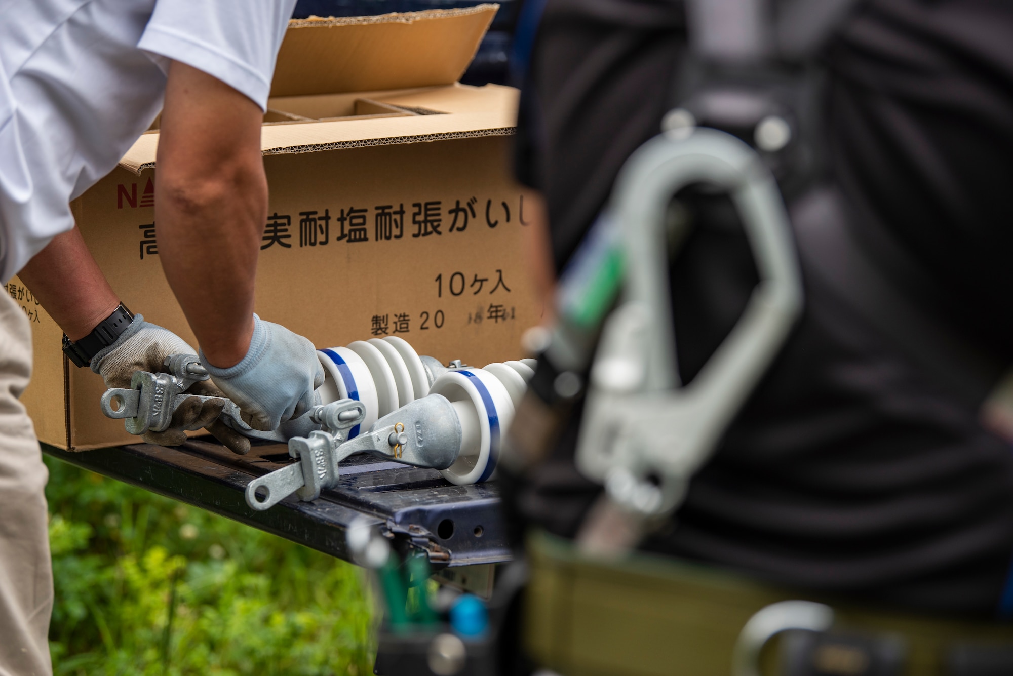 The 35th Civil Engineer Squadron and Japan Air Self-Defense Force Airmen equivalent, work together to replace deteriorating high voltage overhead lines at Draughon Range in Misawa, Japan, July 15.