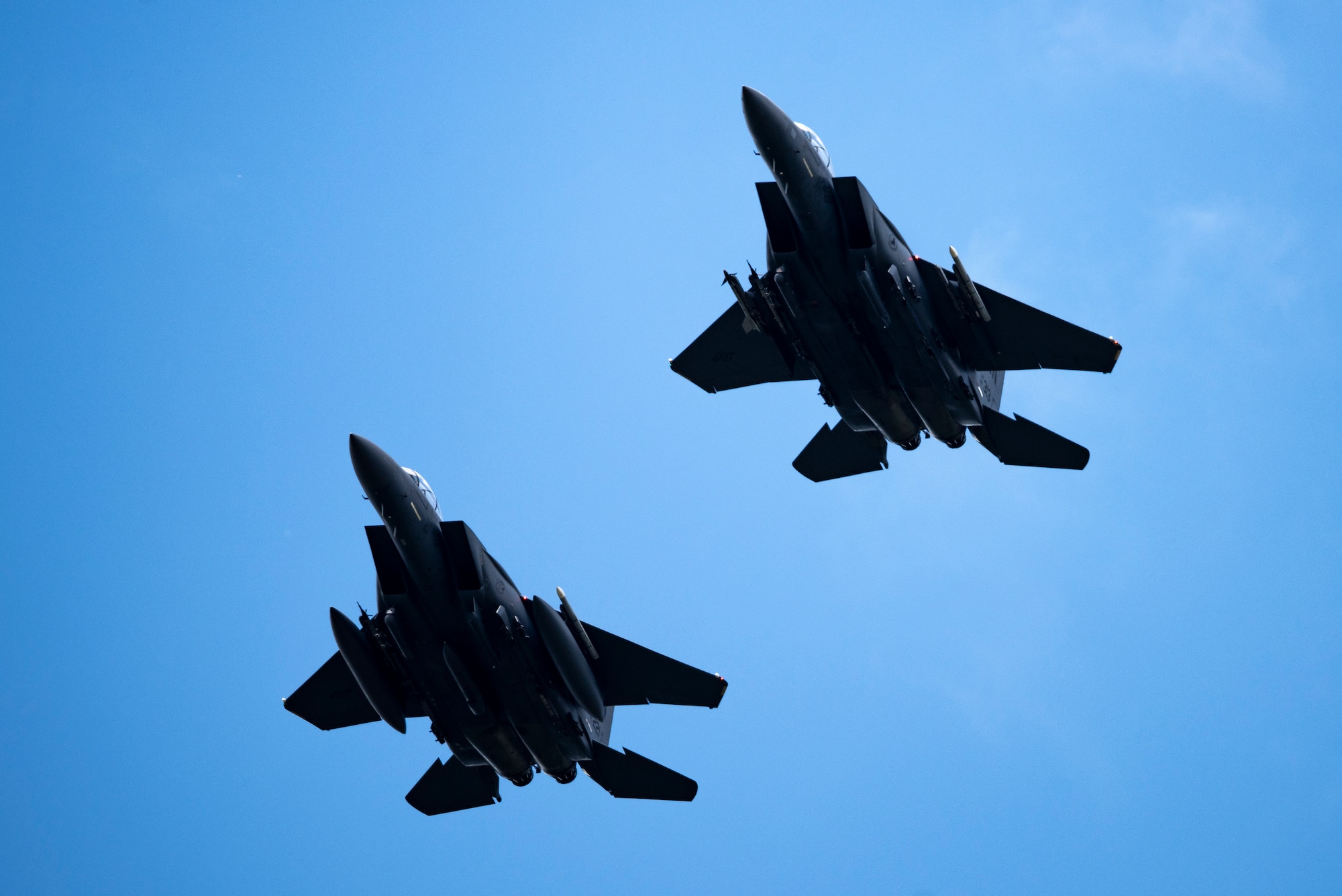 Two U.S. Air Force F-15E Strike Eagles assigned to the 48th Fighter Wing fly over Royal Air Force Lakenheath, England, July 20, 2020. The Liberty Wing conducts routine training in order to maintain combat readiness and safeguard U.S. national interests and the collective defense of allies and partners. (U.S. Air Force photo by Airman 1st Class Jessi Monte)