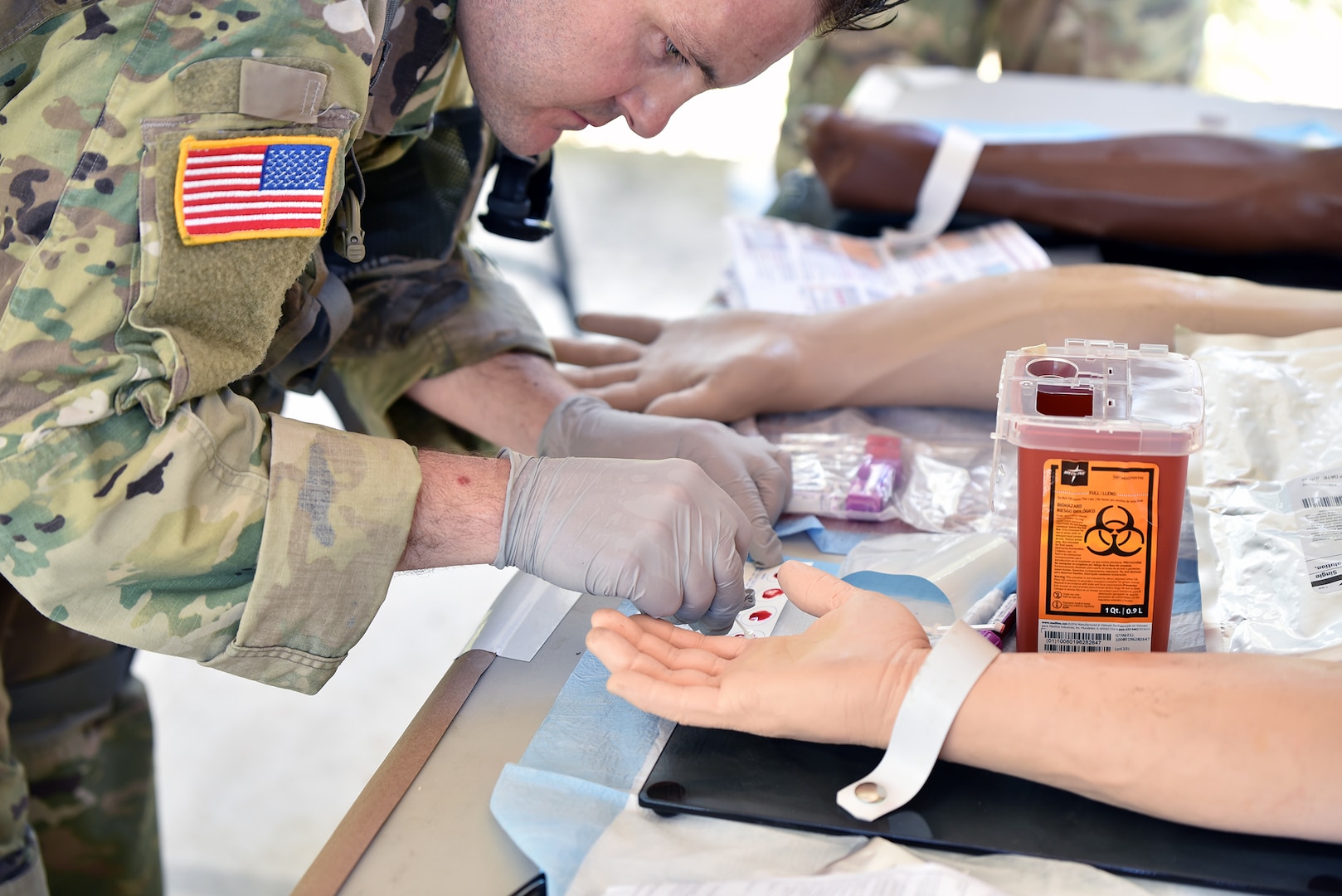 Staff Sgt. Ryan Morgan, 188th Medical Battalion, tests samples of blood to determine their type before preparing to draw whole blood for a simulated transfusion during the Best Medic lane.