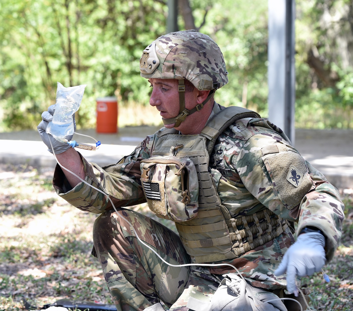 Sgt. 1st Class Jeremy Shepler, Headquarters Medical Professional Training Brigade, prepares to administer intravenous fluids to a simulated casualty on the Best Medic lane.