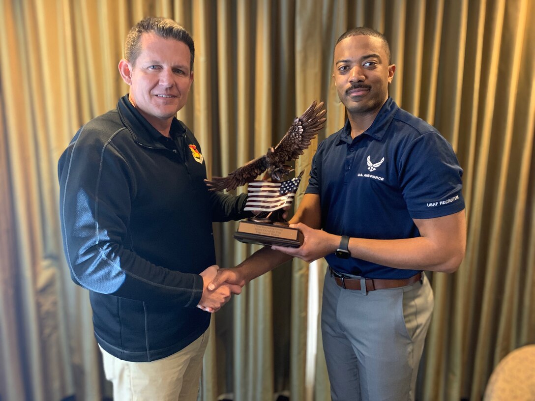 Col. Jason Scott, then 372nd Recruiting Group commander, presents Capt. Jamail Walker with the 2019 Group Company Grade Officer of the Year award during the Officer Professional Development Symposium in Ogden, Utah, January 2020.