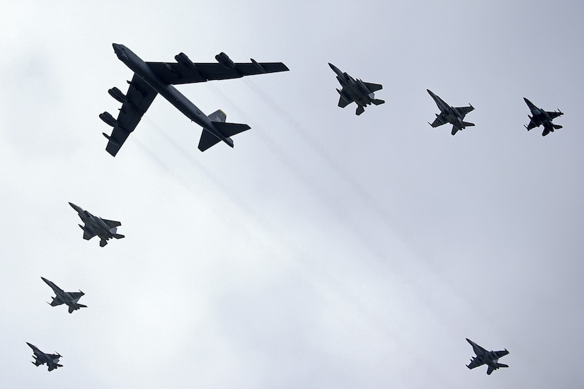 Aircraft from three nations fly in formation.